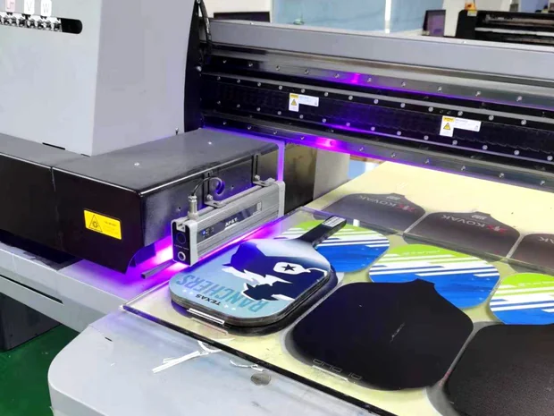 Custom pickleball paddles being printed on a flatbed press during production